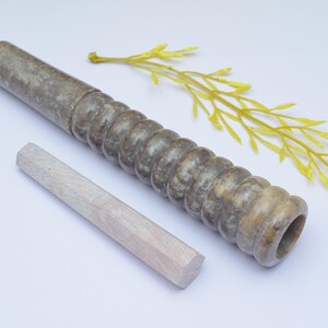Può includere: Una pipa in pietra marrone e grigia con un design a coste e un tampone in legno. La pipa è lunga circa 25 cm.