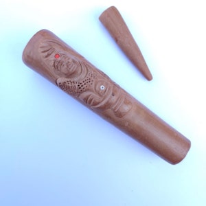 Puede incluir: Una pipa de fumar de madera con una cara tallada y una boquilla de madera separada. La pipa es marrón y la talla es detallada.
