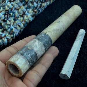 Könnte beinhalten: Zwei Marmorsmokerpfeifen. Die größere Pfeife ist mit schwarzen und grauen Marmorbändern verziert. Die kleinere Pfeife ist aus massivem grauen Marmor.
