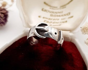 以下が含まれることがあります： 赤いベルベットの内装が施されたヴィンテージのジュエリーボックスに入った、ベルトのバックル型のシルバーリング。 リングは詳細なバックルデザインで、数字の10が刻印されています。
