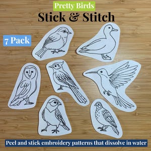 Peut inclure: Ensemble de sept motifs de broderie autocollants représentant des oiseaux. Les motifs sont dessinés en noir sur fond blanc. Le texte "Pretty Birds Stick & Stitch" et "7 Pack" est visible.