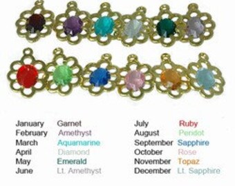 Puede incluir: Doce abalorios de tono dorado con piedras de cristal de colores, que representan las piedras de nacimiento de cada mes del año. Los abalorios tienen forma de flor con una piedra redonda en el centro. Las piedras son rojas, moradas, azules, verdes, azules claras, rosas, amarillas y transparentes.