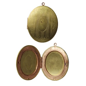May include: A gold oval locket with a hinged lid. The locket has a floral design and a smooth, polished surface.