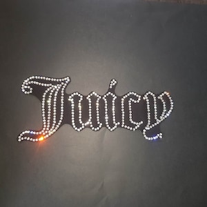 May include: A black fabric patch with the word "Juicy" spelled out in rhinestones.