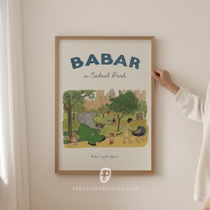 Op de afbeelding: Een ingelijste print met de tekst "BABAR in Central Park" in blauw. De illustratie toont Babar de olifant in een groen pak, samen met andere figuren in een park. De print zit in een houten lijst.