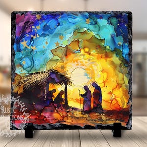May include: A colorful abstract painting on a slate tile depicting the nativity scene. The painting features a star-filled sky, a golden glow, and a silhouette of a stable with three figures.