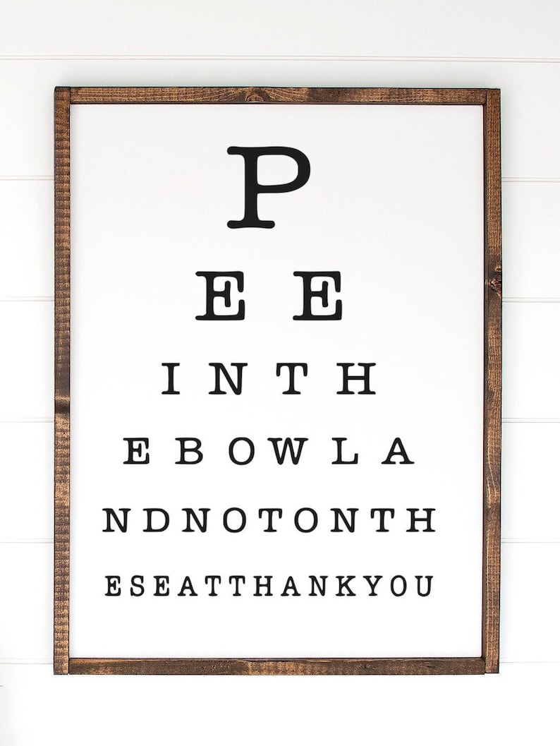 May include: A rectangular wall sign with a dark brown wooden frame and a white background. The sign features black text arranged like an eye chart, reading: P, E E, I N T H, E B O W L A, N D N O T O N T H, E S E A T T H A N K Y O U in descending rows.