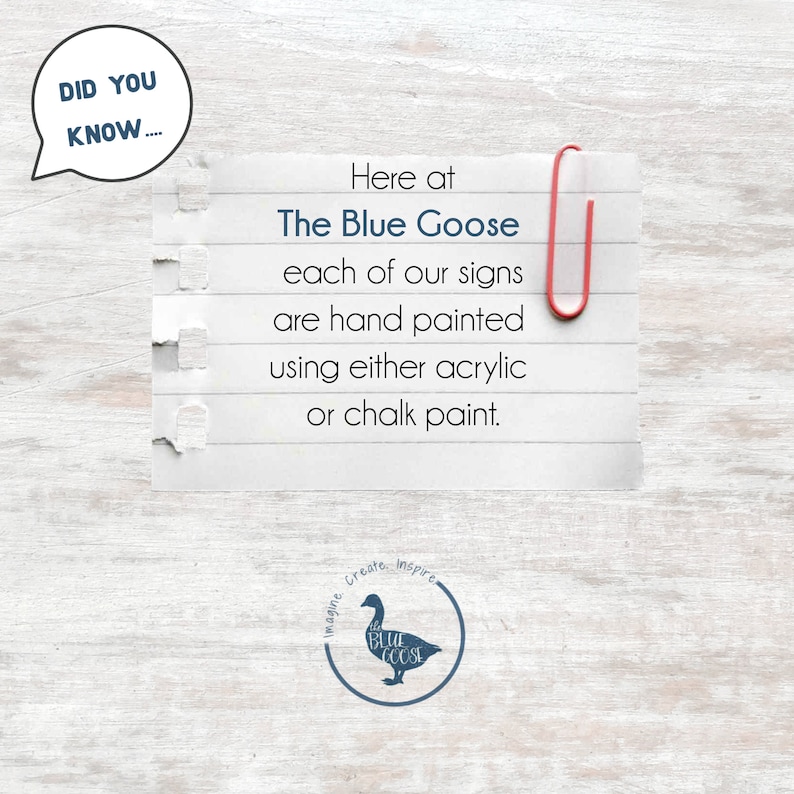 May include: A handwritten note on lined paper with a red paperclip attached, stating "Here at The Blue Goose each of our signs are hand painted using either acrylic or chalk paint."  The note is on a white wood background with a blue goose logo in the bottom right corner.