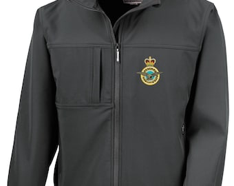 May include: A charcoal gray softshell jacket with a full-length zipper and a stand-up collar. The jacket features a small pocket on the chest and a gold and blue emblem on the left breast. The brand name "Result" is visible on the collar.