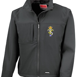 May include: A dark grey softshell jacket with a full zip, a stand-up collar, and an embroidered emblem on the chest. The jacket features a chest pocket and the brand name is visible on the zip and hem.