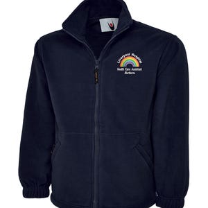 May include: Navy blue fleece jacket with a full zip and a high collar. The jacket features a rainbow logo with the text "Liverpool Hospital Health Care Assistant Barbara". The jacket has two front pockets.