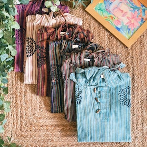 Peut inclure: Une pile de sept chemises rayées colorées avec différents motifs et designs. Les chemises sont en coton et ont une coupe décontractée.