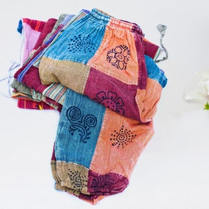 May include: A pair of colourful patchwork trousers with a floral print. The trousers are made from a soft, comfortable fabric and have a relaxed fit.