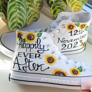 May include: White canvas high-top sneakers with a sunflower design and the text "happily ever after" on one shoe and "12th November 2023" on the other.