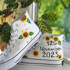May include: White high-top canvas shoes with hand-painted sunflowers and the text "12th November 2023".