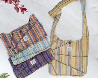 May include: Four striped fabric bags with a single larger striped fabric bag. The smaller bags are stacked on top of each other. The bags are all made of a soft, woven fabric and have a simple, minimalist design. The bags have a label with the word "SUNRISE" on them.