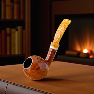 Op de afbeelding: Een houten tabakspijp met een afgeronde ketel en een gebogen steel. De ketel is warmbruin van kleur met een houtnerfpatroon. De steel is licht amber van kleur met een textuurontwerp. Een witte band bevindt zich bij de basis van de steel.