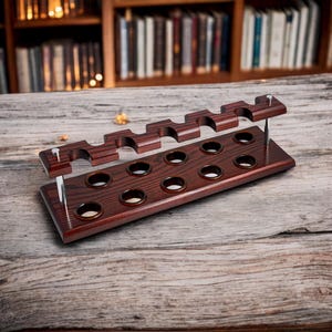 May include: A dark red wooden pipe rack with 10 round holes and 6 slots for pipes. The rack is made of wood with a grain pattern and has a silver metal accent.