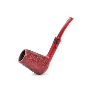 Peut inclure: Une pipe à tabac rouge avec un foyer texturé et une tige lisse et incurvée. Le foyer est d'une nuance de rouge plus foncée, tandis que la tige est d'un rouge plus clair et translucide. Les initiales "KAF" sont imprimées sur la tige.