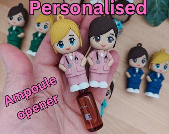 May include: A set of personalised nurse figurines with a small glass bottle. The figurines are wearing pink scrubs and have a stethoscope around their necks. The text "Personalised" is written in pink letters above the figurines. The text "Ampoule opener" is written in pink letters below the figurines.
