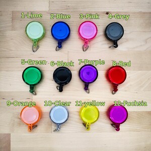 May include: Twelve retractable badge holders in various colours, including lime, blue, pink, grey, green, black, purple, red, orange, clear, yellow, and fuchsia.