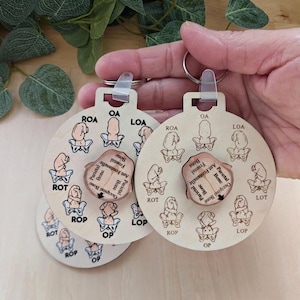 May include: Wooden keychains with a round design featuring anatomical illustrations and text. The keychains have a light wood finish and include a rotating central piece with labeled bone diagrams. The keychains are held by a person.