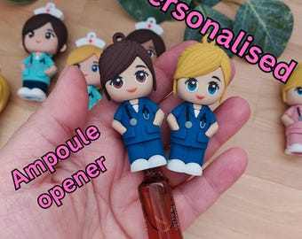 May include: Two blue and white nurse figurines with a stethoscope, holding a small brown glass bottle with a clear cap. The bottle is labelled "LOTION" and has a white label with black text. The figurines are labelled "Personalised Ampoule opener".