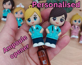 May include: Personalised blue and white nurse figurine bottle opener with a brown glass ampoule. The figurine is holding a stethoscope and has a white cap. The text "Ampoule opener" is written in pink on a white background. The text "Personalised" is written in pink on a white background.