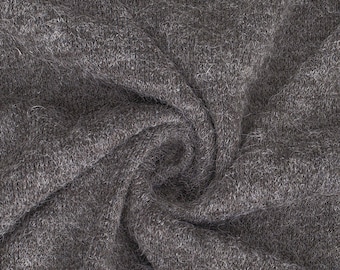 Puede incluir: Primer plano de una tela gris antracita con una textura suave y peluda. La tela está doblada y drapeada, creando un patrón de remolino.
