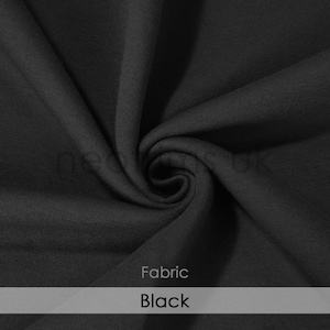 Puede incluir: Primer plano de una tela negra. La tela es suave y tiene una textura lisa. Tela: Negra.
