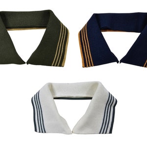 Könnte beinhalten: Drei verschiedene farbige Strickkragen mit kontrastierenden Streifen. Die Kragen sind grün mit braunen Streifen, dunkelblau mit orangefarbenen Streifen und weiß mit schwarzen Streifen.