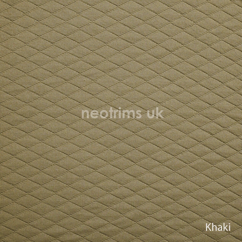 K&ouml;nnte beinhalten: Khakifarbener Stoff mit einem gesteppten Rautenmuster. Der Stoff hat eine strukturierte Oberfl&auml;che und eignet sich f&uuml;r verschiedene N&auml;h- und Bastelprojekte. Der Text "neotrims uk" ist auf dem Stoff sichtbar, ebenso wie das Wort "Khaki".