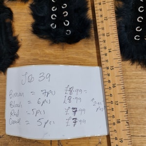 May include: A handwritten price list for fur trim with prices listed in British pounds. The list includes the colors brown, black, red, and cream. The price for each color is listed next to the quantity of pieces available.
