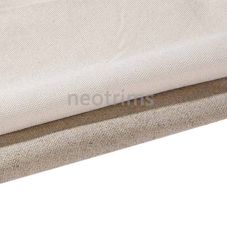 May include: Two pieces of fabric, one white and one beige, are folded over each other. The white fabric is on top and has a smooth texture. The beige fabric is underneath and has a rougher texture.
