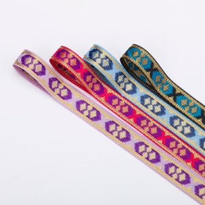 May include: Five different colors of patterned ribbon with gold accents. The ribbons are woven with a floral design and are arranged in a row.