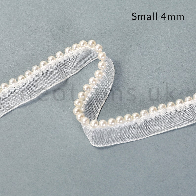 May include: White pearl trim ribbon with a sheer mesh backing. The trim is 4mm wide and has small, evenly spaced pearls.