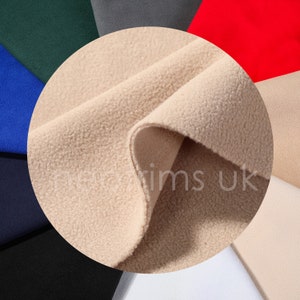 May include: Close-up of a beige fleece fabric. The fabric is soft and fuzzy, and it is perfect for making warm clothing or blankets.