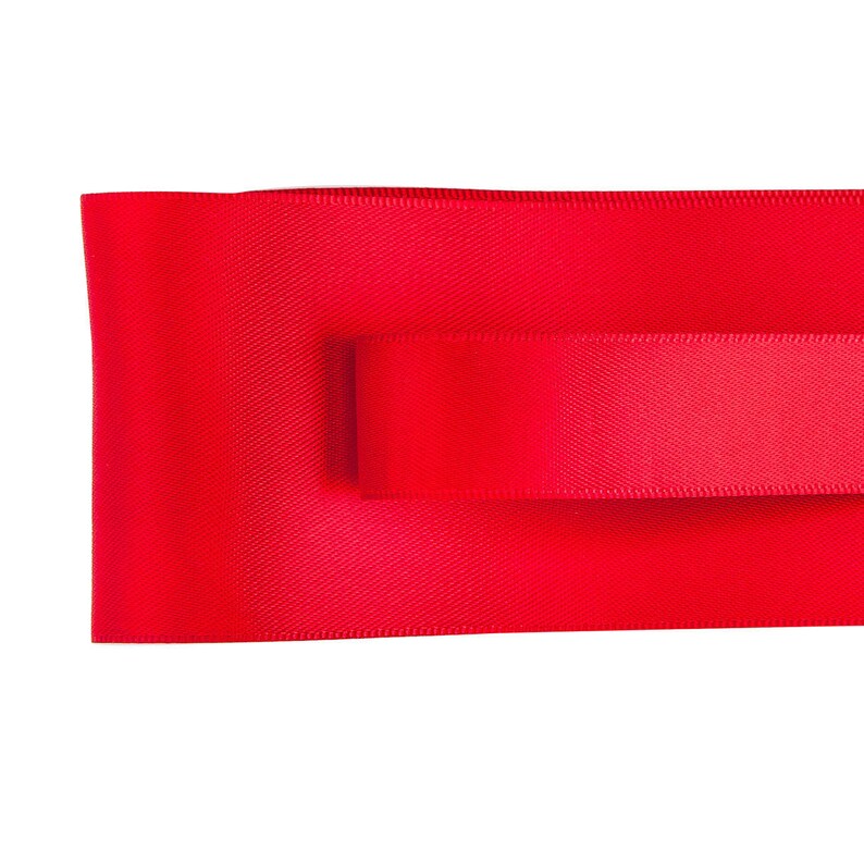 May include: Two pieces of red satin ribbon, one on top of the other.