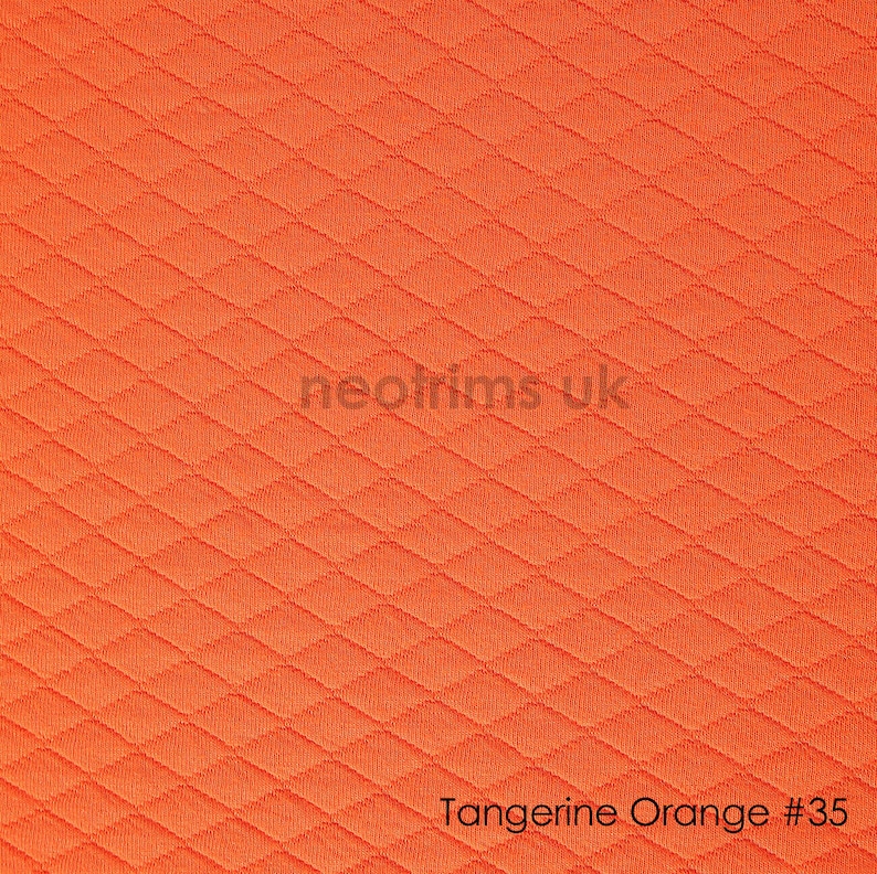 May include: Tangerine orange fabric with a diamond pattern. The fabric is textured and has a subtle sheen.
