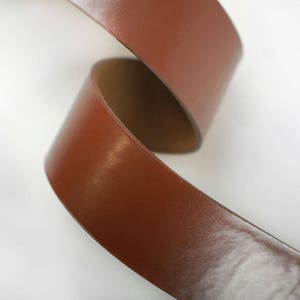 K&ouml;nnte beinhalten: Nahaufnahme eines braunen Lederriemens, der die Textur und Maserung des Leders zeigt.