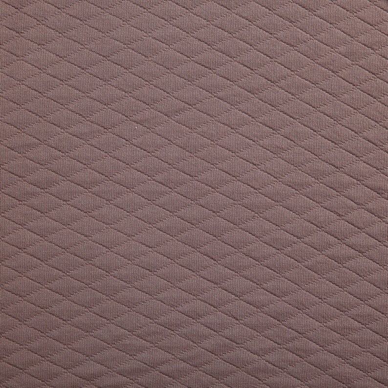 Peut inclure: Gros plan sur un tissu textur&eacute; avec un motif en diagonale. Le tissu est de couleur brun clair.