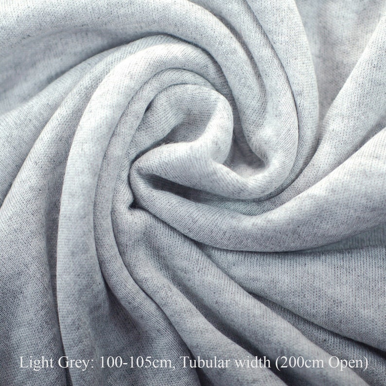 May include: Light grey fabric, folded and twisted, showing the texture of the material. The fabric is 100-105cm wide and has a tubular width of 200cm when open.