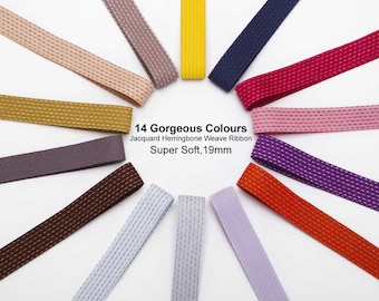 May include: 14 Gorgeous Colours Jacquard Herringbone Weave Ribbon Super Soft, 19mm. A variety of colors of ribbon are arranged in a circle on a white background. The ribbon is 19mm wide and has a herringbone weave.