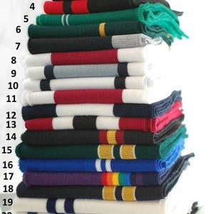May include: A stack of 22 different colored knit fabric trims with white, black, red, green, blue, purple, and yellow stripes. The trims are numbered 1 through 22.