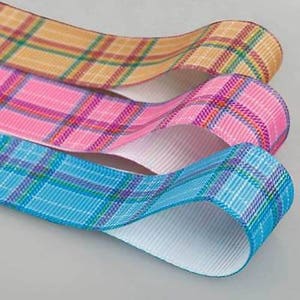 May include: Three rolls of plaid ribbon in different colours: orange, pink, and blue. The ribbons are folded and stacked on top of each other.