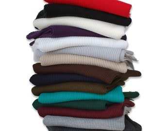 Könnte beinhalten: Ein Stapel aus 14 verschiedenen, gerippten Strickstoffbändern in verschiedenen Farben. Die Farben sind rot, schwarz, weiß, lila, beige, braun, dunkelblau, olivgrün, türkis, dunkelgrün, burgunderrot, grau und anthrazit.