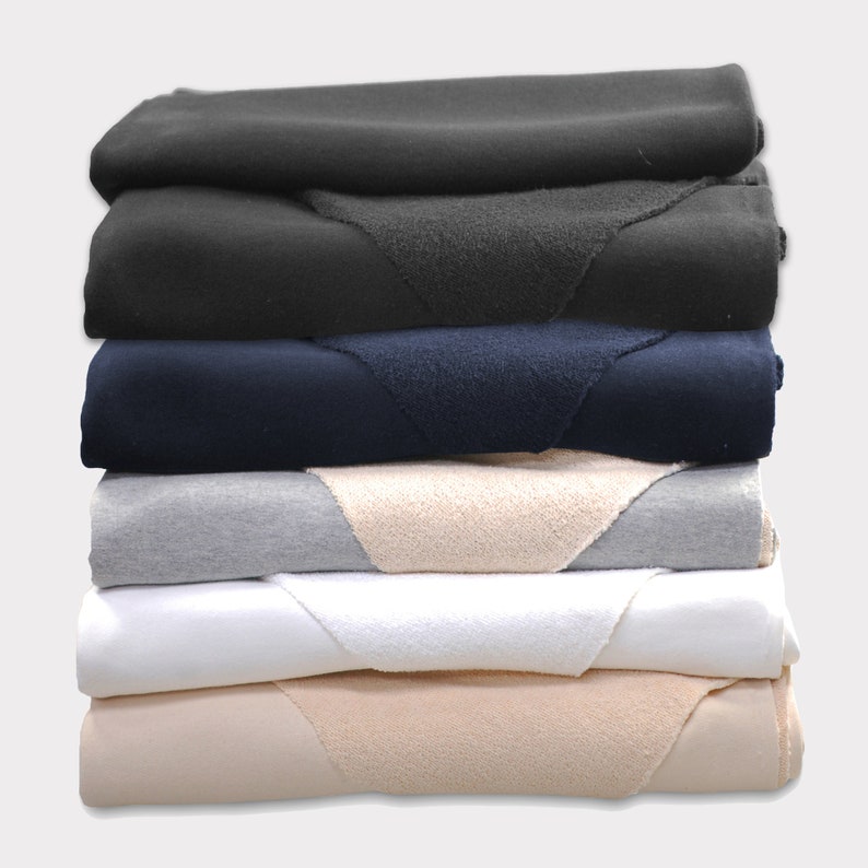 Puede incluir: Un conjunto de seis muestras de tela en varios colores, incluyendo negro, azul marino, gris, blanco y beige. Cada muestra tiene una textura diferente, algunas son lisas y otras son peludas.