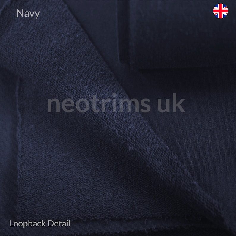 Puede incluir: Primer plano de tejido de bucle azul marino. El tejido es suave y texturizado, con un detalle de bucle visible en la parte inferior. El texto "neotrims uk" es visible en la imagen.