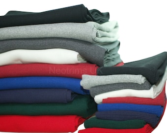 May include: A stack of different colored ribbed knit fabric. The fabric is folded and stacked in a pile. The colors are black, gray, white, red, blue, green, and navy. The fabric is sold by the meter.