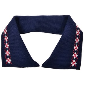 May include: A navy blue knitted collar with a red and white embroidered pattern around the edges.